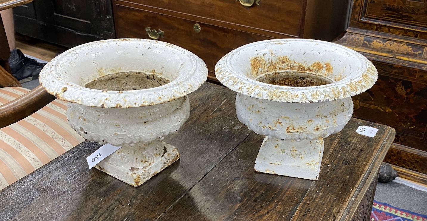 A pair of small Victorian cast iron campana urns, diameter 28cm, height 20cm